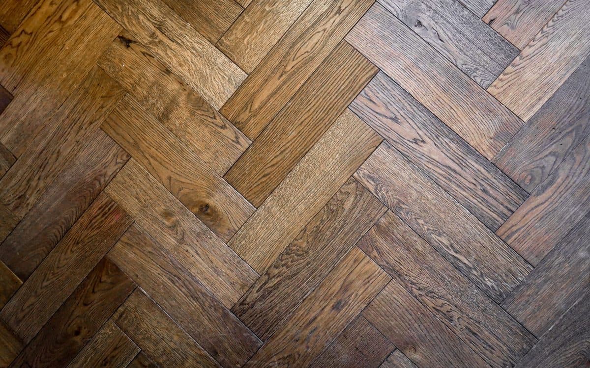 Échantillons de bois franc et de plancher flottant stratifié côte à côte sur un plancher