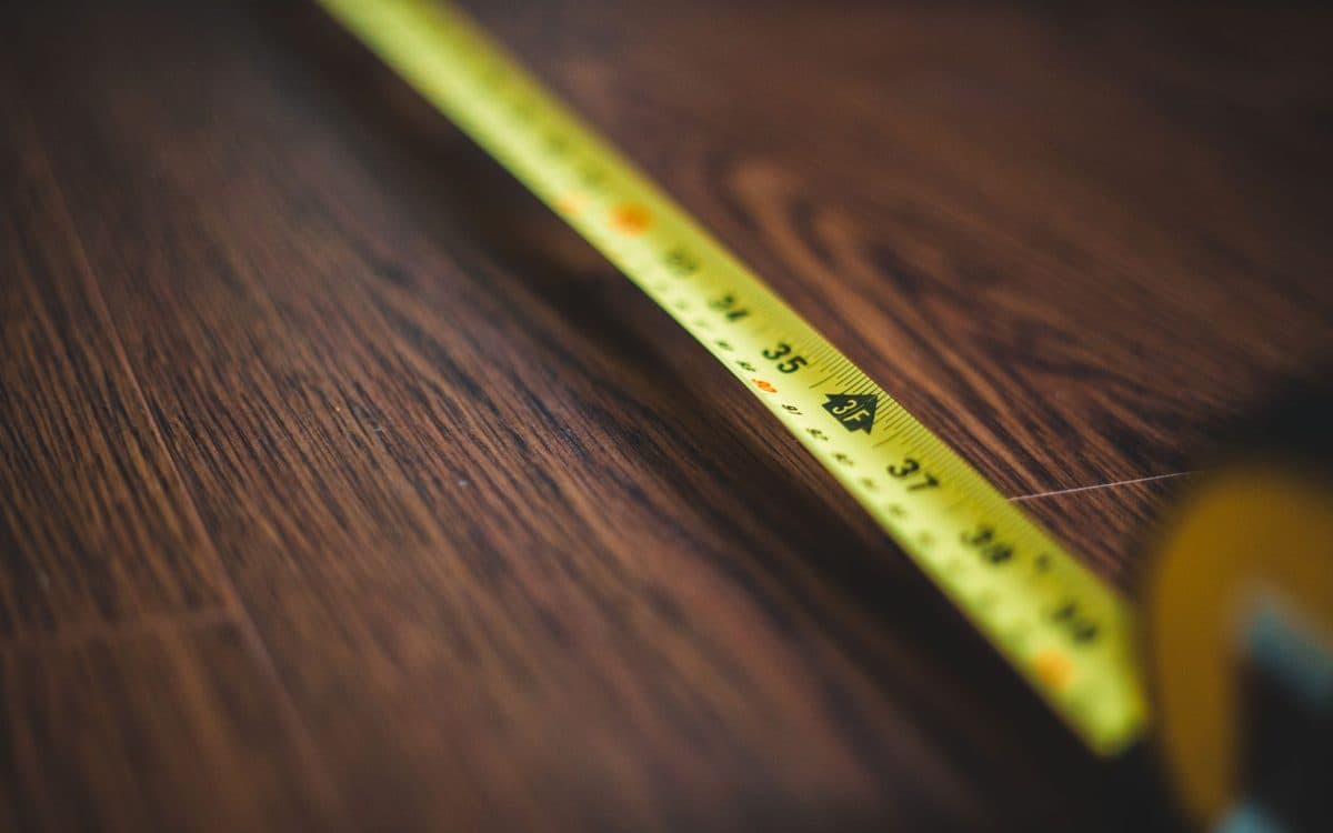 Installateur mesurant une pièce avant la pose d'un plancher flottant dans une maison de Montréal